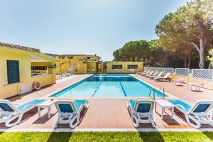 a pool with chaise lounge chairs and a swimming pool at Hotel Fiore Di Maggio in Villasimius