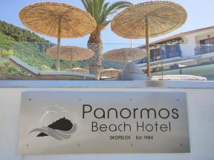 a sign for panomos beach hotel with umbrellas at Panormos Beach Hotel Skopelos in Panormos Skopelos