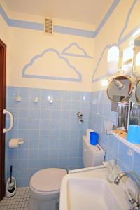 a bathroom with a toilet and a cloud painted on the wall at Vier Jahreszeiten 6-4 in Großenbrode