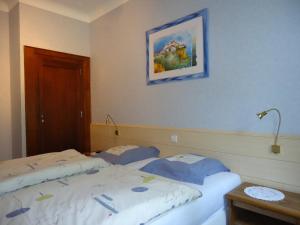 a bedroom with two beds and a picture on the wall at Hostellerie de la Vallée in Heffingen