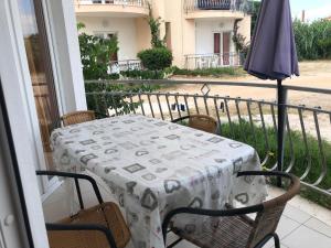 a table and chairs on a balcony with an umbrella at Apartmani Šaldi in Pakoštane