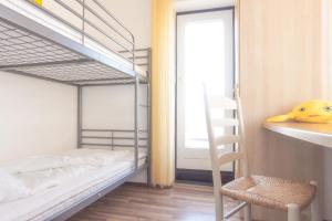 ein kleines Schlafzimmer mit Etagenbetten und einer Leiter in der Unterkunft Vier Jahreszeiten 4-34 in Großenbrode