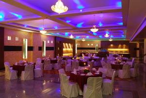 a banquet hall with tables and chairs and purple lighting at HK Clarks Inn, Amritsar in Amritsar +32 photos