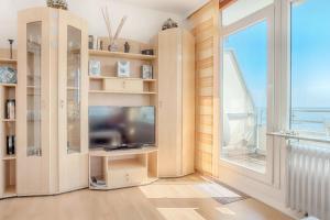 ein Wohnzimmer mit einem TV und einem großen Fenster in der Unterkunft Vier Jahreszeiten 4-34 in Großenbrode