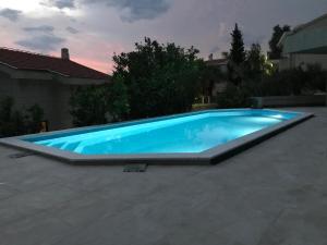 a large blue swimming pool in a backyard at Reževići Apartments in Petrovac na Moru
