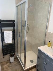 a shower with a glass door in a bathroom at The Croft Apartment in Bourton on the Water