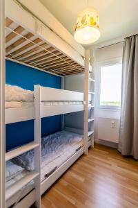 ein Schlafzimmer mit Etagenbetten und einer blauen Wand in der Unterkunft Vier Jahreszeiten 2-80 in Großenbrode