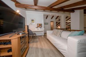 a living room with a white couch and a television at Villa Bella in Banjol
