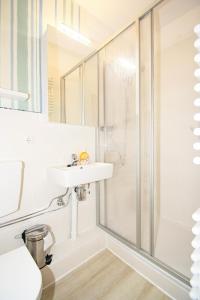 uma casa de banho com um lavatório e um chuveiro em Vier Jahreszeiten 6-10 em Grossenbrode