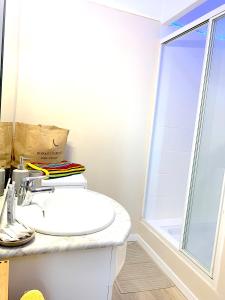 a white bathroom with a sink and a window at 2 Pièces Liberté Plein Centre in Saint-Raphaël +18 photos