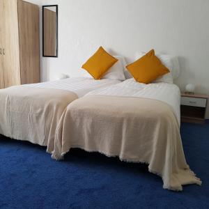 a bedroom with two beds with white and yellow pillows at B&b Broodhuis Kerkrade in Kerkrade