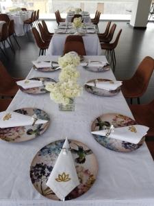 a table with plates and flowers on top of it at Hotel Amiraty in Ipiales