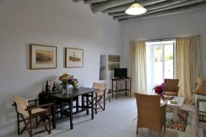 a living room with a dining room table and chairs at Apatouria Farmhouse in Andros