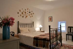 a bedroom with a bed and a vase with flowers at Apatouria Farmhouse in Andros