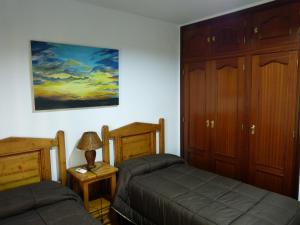 Casa La Antigua Almazara في كازورلا: غرفة نوم بسريرين ولوحة على الحائط