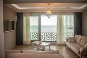 a living room with a couch and a view of the ocean at Yildiz Apart Hotel in Fatsa