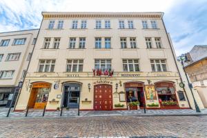 duży budynek z czerwonymi drzwiami na ulicy w obiekcie Hotel Salvator w Pradze