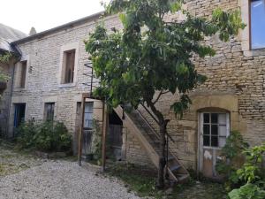 ein Backsteingebäude mit einer Holztreppe neben einem Baum in der Unterkunft Casabann in Langrune-sur-Mer
