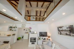a living room with white walls and wooden ceilings at Villa Bella in Banjol