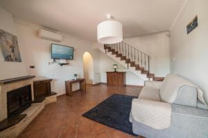 un salon avec un canapé et une télévision à écran plat dans l'établissement SEASIDE COTTAGE LADISPOLI CERRETO, à Ladispoli