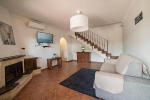 een woonkamer met een bank en een flatscreen-tv bij SEASIDE COTTAGE LADISPOLI CERRETO in Ladispoli