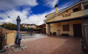 un patio avec des parasols et une table ainsi qu'un bâtiment dans l'établissement SEASIDE COTTAGE LADISPOLI CERRETO, à Ladispoli