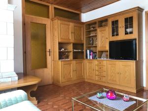 un soggiorno con armadi in legno e TV di Appartamento Pezzol a Daiano
