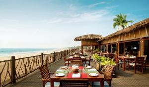 a patio area with tables, chairs and umbrellas at Taj Holiday Village Resort & Spa, Goa in Candolim