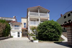 a white building with a balcony on the side of it at Apartments Domic in Banjole