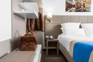 a hotel room with a bed and a backpack at Kyriad Lyon Est Stadium Eurexpo Meyzieu in Meyzieu +40 photos
