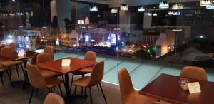 Hotel Amiraty في إبياليز: مطعم به طاولات وكراسي ومطل على مدينة