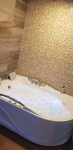 Hotel Amiraty في إبياليز: حوض الاستحمام جالس على أرضية خشبية