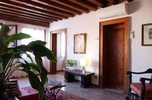 un soggiorno con scrivania e pianta di Appartamenti San Luca a Venezia