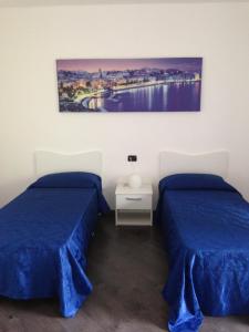 Zimmer mit 2 Betten und Wandgemälde in der Unterkunft Affittacamere Derby in Ranica
