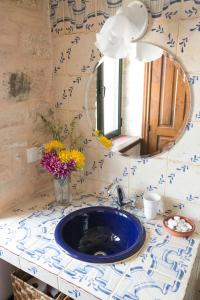 y baño con lavabo azul y espejo. en Cortijo El Derramadero, en Villacarrillo