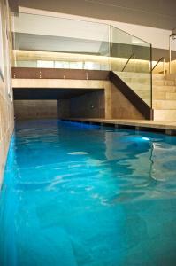 - une piscine d'eau bleue dans un bâtiment dans l'établissement Residence Alleterme, à Rivanazzano Terme