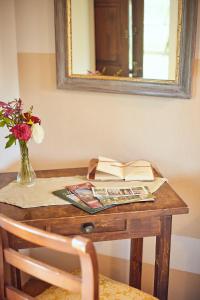a table with a book and a vase of flowers at Agriturismo Palazzi Del Papa in Pienza