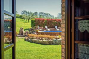 een raam met uitzicht op een tuin vanuit een huis bij Agriturismo Palazzi Del Papa in Pienza