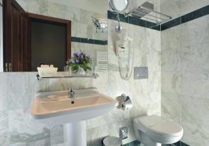 a bathroom with a sink and a toilet at Grand Hotel Praha in Prague +85 photos