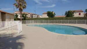a swimming pool with a fence around it at Grandes Bleues, Appartement T3 duplex, piscine, Narbonne Plage in Narbonne-Plage