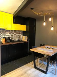 a kitchen with a wooden table and yellow cabinets at Lascăr Catargiu Vila in Bucharest