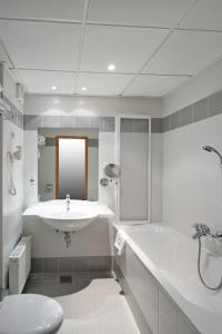 a bathroom with a sink and a tub and a toilet at Ramada Resort Kranjska Gora in Kranjska Gora