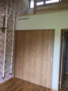 una gran puerta de madera en una habitación en Guesthouse Kazenowa, en Asahi