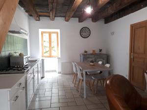 a kitchen with a table and a clock on the wall at Le Bolet in Flaujac-Gare