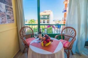 ein Tisch mit einer Flasche Wein und einer Schale Obst in der Unterkunft Apartamento Hidalgo in Puerto de la Cruz