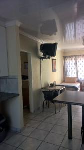 Sala de estar con cama y mesa en Amberlight Self Catering Accommodation en Krugersdorp