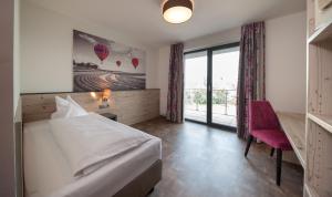 a hotel room with a bed and a desk and a window at Motel 267 in Sankt Pölten