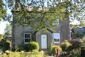 a gray brick house with a white door at Ellenboro House Bed & Breakfast & self-catering in Cartmel