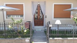 ein Haus mit einer Holztür und einem Zaun in der Unterkunft Luce in Lucca