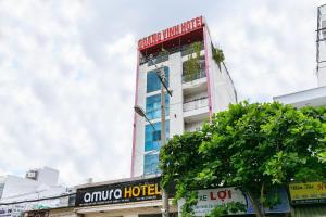 un edificio alto con un rojo y blanco en Amura Hotel Quận 7, en Ho Chi Minh